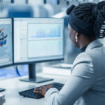 A person sitting at a computer working on a CAD model